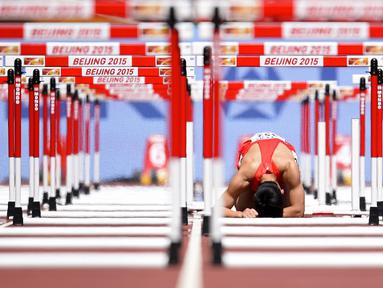 Kesedihan pelari Tiongkok, Zhang Honglin, setelah terjatuh dalam nomor lari gawang 110m putra Kejuaraan Dunia Atletik 2015 di Stadion Nasional, Beijing, Tiongkok. (26/8/2015). (AFP Photo/Olivier Morin)