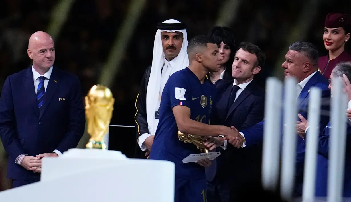 Pemain Prancis Kylian Mbappe berjabat tangan dengan Presiden Asosiasi Sepak Bola Argentina Claudio Tapia saat menerima penghargaan Sepatu Emas usai pertandingan sepak bola final Piala Dunia 2022 di Stadion Lusail, Lusail, Qatar, 18 Desember 2022. Kylian Mbappe berhak membawa pulang trofi penghargaan Sepatu Emas setelah menjadi pencetak gol terbanyak selama gelaran Piala Dunia 2022. (AP Photo/Natacha Pisarenko)