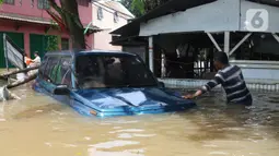 Warga melihat kondisi mobil yang terseret arus banjir di perumah Ciledug Indah, Tangerang, Banten, Kamis (2/1/2020). Sebelumnya, media sosial diramaikan dengan video sejumlah mobil yang terseret arus banjir hingga ratusan meter ke arah dalam perumahan Ciledug Indah. (Liputan6.com/Angga Yuniar)