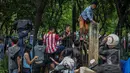 Sejumlah warga memanjat pagar untuk menyaksikan Konser Drug Free Asia Africa di kawasan Monas, Jakarta, Minggu (19/4/2015). Aksi nekat warga ini ditengarai oleh petugas yang menutup akses masuk pengunjung Monas. (Liputan6.com/Faizal Fanani)