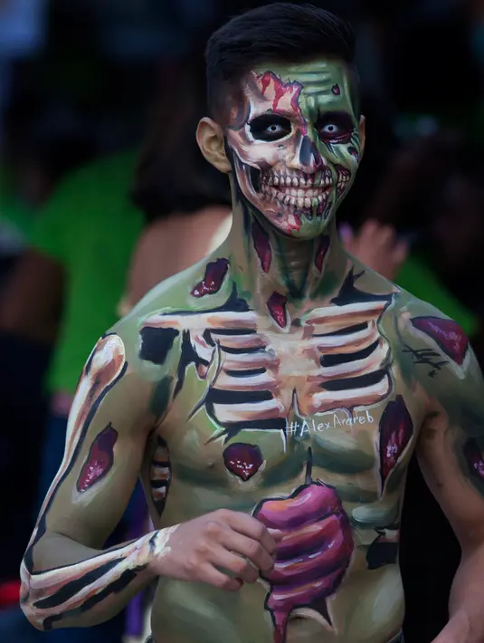 Seorang pria berpartisipasi dalam Zombie Walk di Mexico City, Minggu (11/11). Dalam acara tahunan itu ratusan orang dengan penampilan yang seram serta mengenakan pakaian compang-camping berkumpul di pusat bersejarah ibu kota Meksiko. (AP/Claudio Cruz)