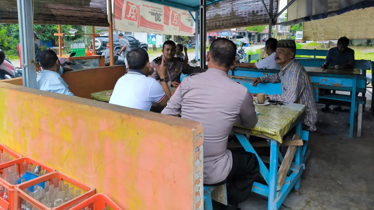 Personel Polres Rokan Hulu berdialog dengan warga di warung kopi.
