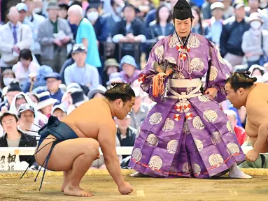 Pegulat sumo bersiap untuk bertanding dalam turnamen Honozumo di Kuil Yasukuni, Tokyo, Jepang, 15 April 2019. Turnamen seremonial ini diikuti oleh para jawara sumo. (TRIBALLEAU CHARLY/AFP)