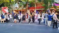 Sekelompok orang yang berada di seberang jalan atau depan lokasi deklarasi Anies-Cak Imin di Surabaya, menyanyikan Ganjar Presiden. (Liputan6.com/Dian Kurniawan)