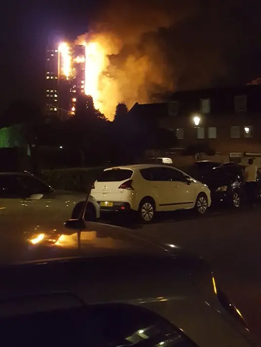 Sejumlah warga menyaksikan kebakaran yang melanda apartemen bertingkat 27 lantai di London (14/6). Wali kota London, mengatakan ini adalah kecelakaan yang besar. Belum diketahui apakah ada korban jiwa dalam insiden tersebut. (AFP PHOTO / Giulio Thuburn)