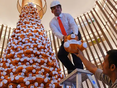 Seorang staff menyusun pohon Natal yang terbuat dari boneka beruang teddy di lobi sebuah hotel di Bangalore, India, Rabu (28/11). Ratusan boneka beruang disusun sedemikian rupa hingga membentuk pohon natal cantik. (MANJUNATH KIRAN / AFP)