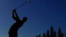 Siluet pegolf Inggris, Danny Willett, saat memukul bola dalam turnamen golf Dubai Desert Classic 2016 di Emirates Golf Club, Dubai, (7/2/2016). (AFP/Karim Sahib)