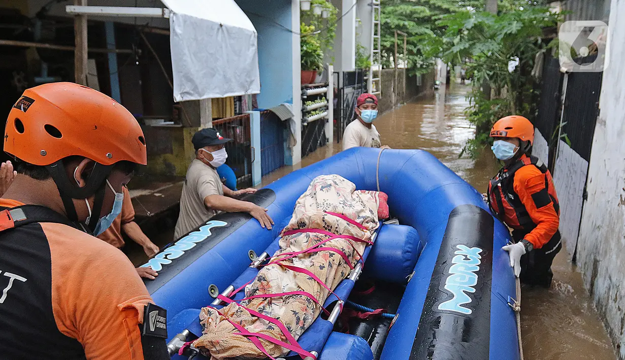 Relawan dan keluarga membawa jenazah warga lansia dengan perahu karet saat banjir di kawasan Cipinang Melayu, Jakarta Timur, Jumat (19/2/2021). Seorang nenek (80) meninggal di kediamannya, di lokasi banjir, di RW 04, kawasan tersebut karena sakit dan sudah lanjut usia. (Liputan6.com/Herman Zakharia)