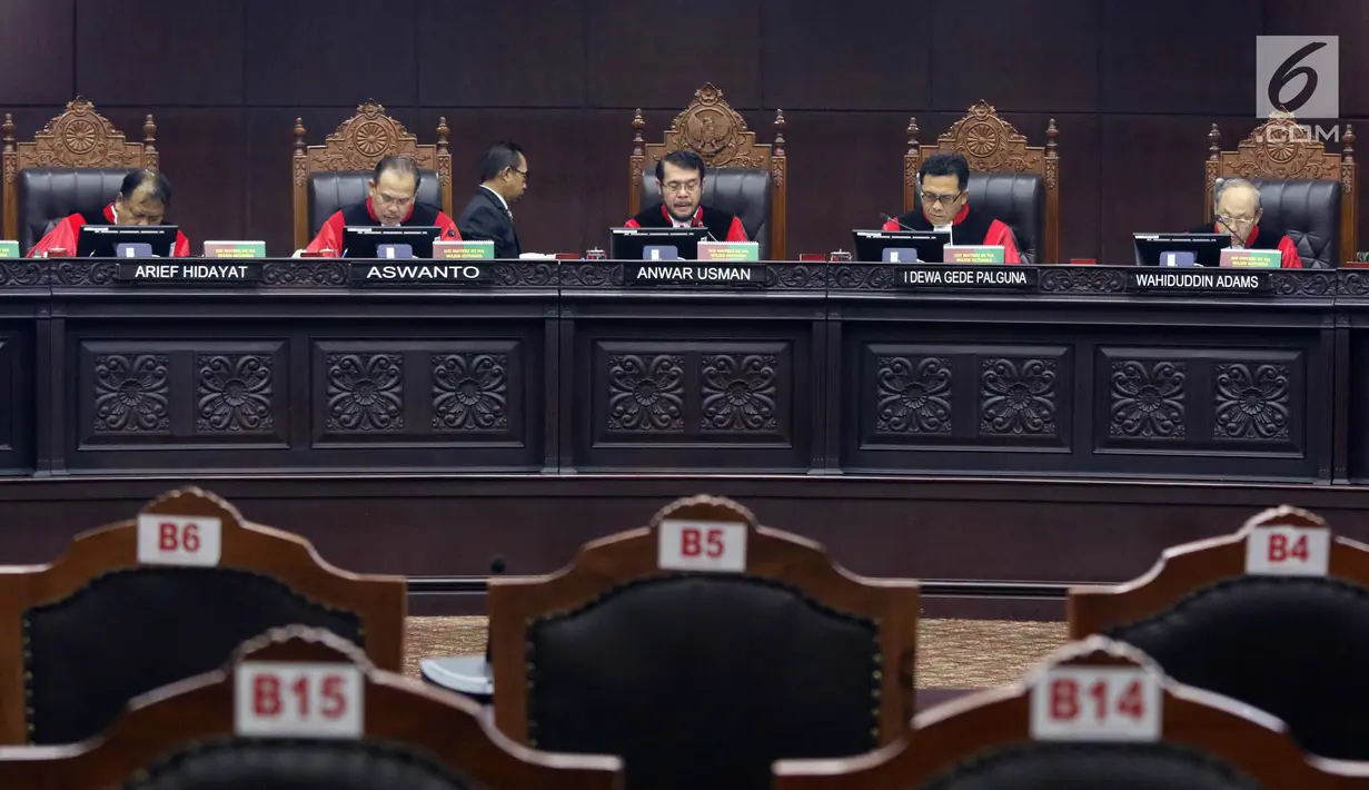 Ketua Majelis Hakim Mahkamah Konstitusi Anwar Usman (tengah) membacakan putusan perkara pengujian undang-undang tentang ASN, Sistem Pendidikan Nasional, Pendidikan dan Gelar Profesi, di Gedung MK, Jakarta, Kamis (14/2). (Liputan6.com/Helmi Fithriansyah)