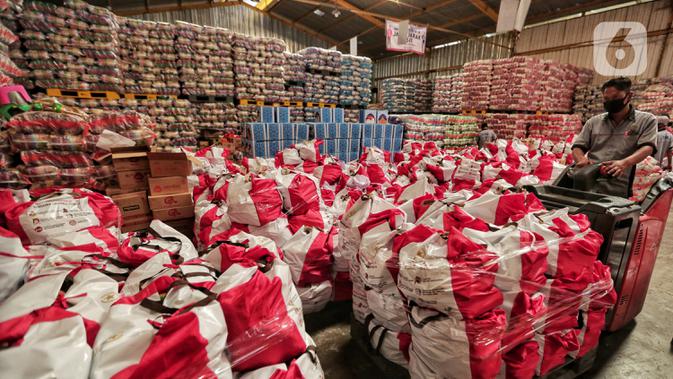 Pekerja memindahkan paket bantuan sosial (bansos) di Gudang Food Station Cipinang, Jakarta, Rabu (22/4/2020). Pemerintah pusat menyalurkan paket bansos selama tiga bulan untuk mencegah warga mudik dan meningkatkan daya beli selama masa pandemi COVID-19. (Liputan6.com/Johan Tallo)