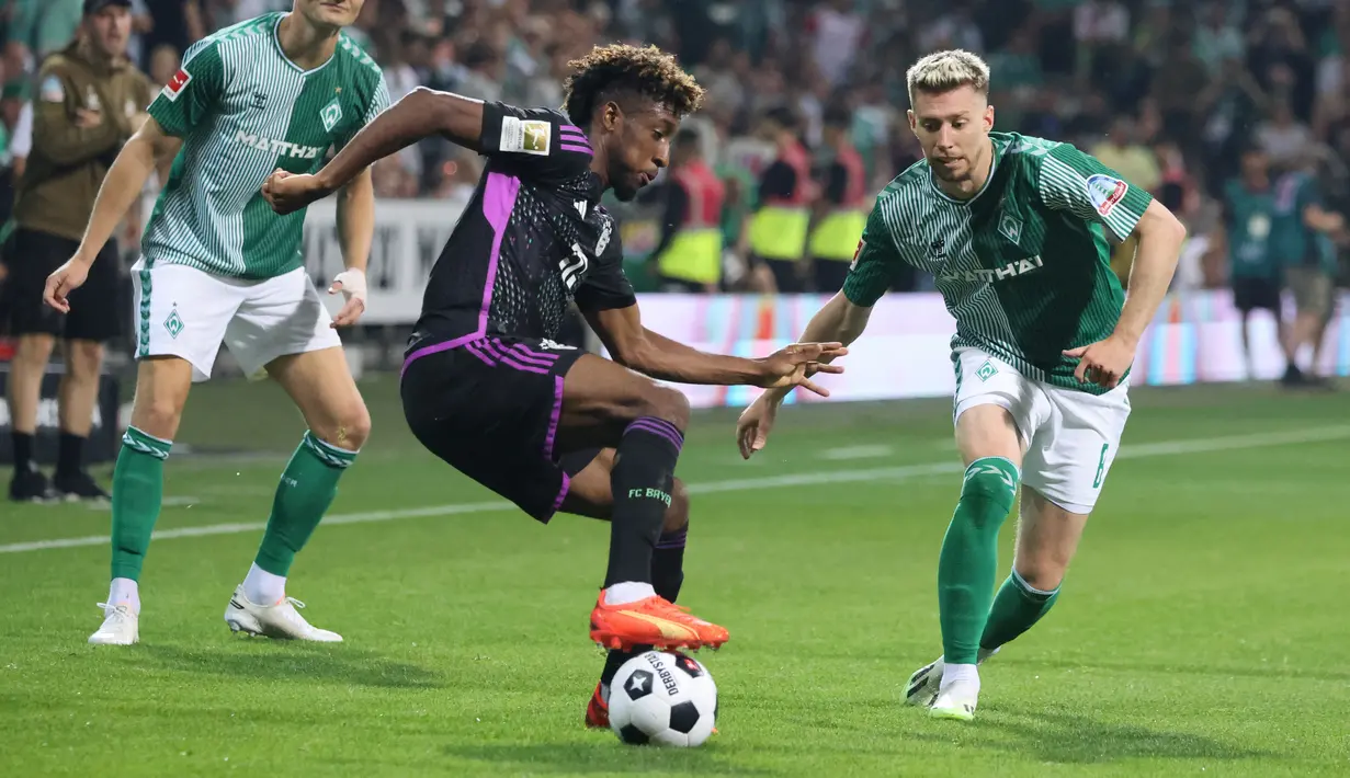 Penyerang Bayern Munchen, Kingsley Coman (Tengah) dan bek Werder Bremen, Mitchell Weiser (kanan) berebut bola dalam laga pekan ke-1 Bundesliga 2023/2024 di Stadion Wesser, Sabtu (19/8/2023) dinihari WIB. (Photo by Focke Strangmann / AFP)