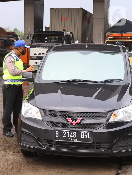 Petugas memeriksa kelengkapan administrasi pengendara saat penyekatan larangan mudik lebaran di gerbang tol Cikupa, Kabupaten Tangerang, Banten, Kamis (6/5/2021). Penyekatan dilakukan seiring telah diberlakukan larangan mudik Lebaran mulai dari 6 hingga 17 Mei 2021.  (Liputan6.com/Angga Yuniar)