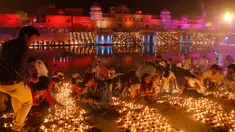 Masyarakat India menyalakan lampu dari tanah liat pada festival Diwali di tepi Sungai Sarayu, Ayodhya, Selasa (6/11). Kota di utara India itu memecahkan rekor dunia Guinness setelah menyalakan 300.150 lampu selama 45 menit. (AP/Rajesh Kumar Singh)