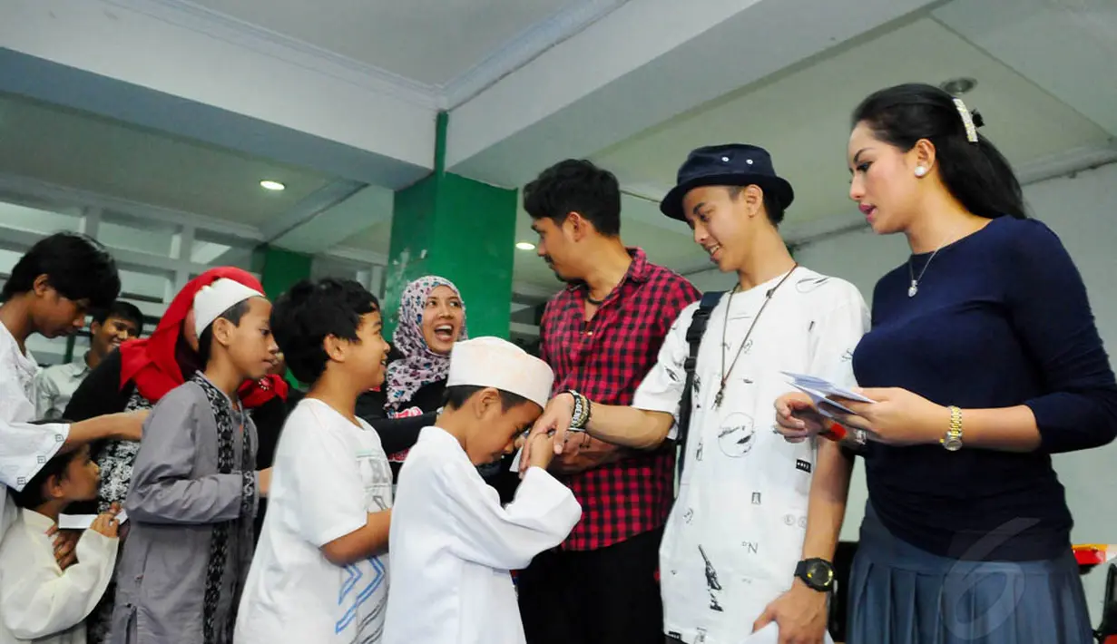 Sejumlah pemain dari ABG Jadi Manten memberikan santunan kepada anak yatim di Rumah Susun Petamburan, Jakarta, Selasa (5/8/14). (Liputan6.com/Andrian M Tunay)