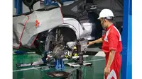 Teknisi sedang memperbaiki kendaraan Mitsubishi di bengkel resmi Mitsubishi Motors. (ist)
