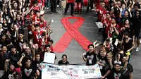 Massa membuat tanda pita sebagai simbol peduli terhadap pengidap HIV/AIDS, di Jalan MH Thamrin, Jakarta, MInggu (30/11/2014). (Liputan6.com/Faizal Fanani) 