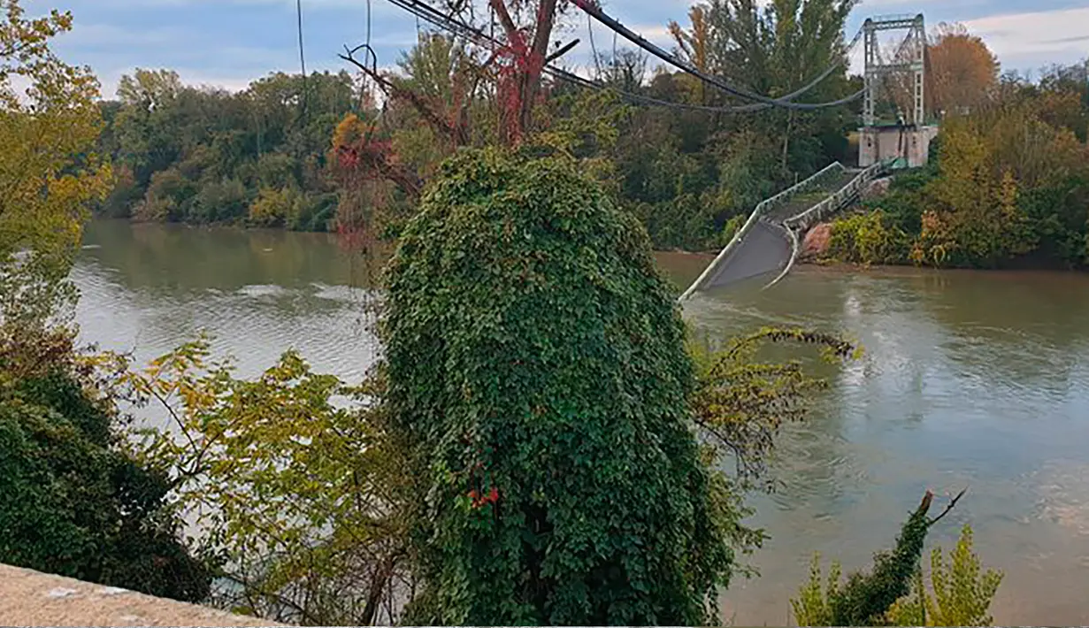 Jembatan gantung penghubung sejumlah kota di wilayah Mirepoix-sur-Tarn dengan Bessieres di atas sungai Tarm ambruk, Prancis, Selasa (18/11/2019). Kepolisian mengungkapkan empat orang berhasil diselamatkan namun beberapa lainnya belum ditemukan setelah jembatan itu ambruk. (Olivier Le Corre via AP)