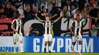 Paulo Dybala bersama rekan setimnya merayakan gol saat perempat final leg pertama Liga Champions antara Juventus vs Barcelona di Juventus Stadium, Italia, Rabu (12/4). Juve menceploskan 3 gol tanpa balas. (AFP PHOTO / Marco BERTORELLO)