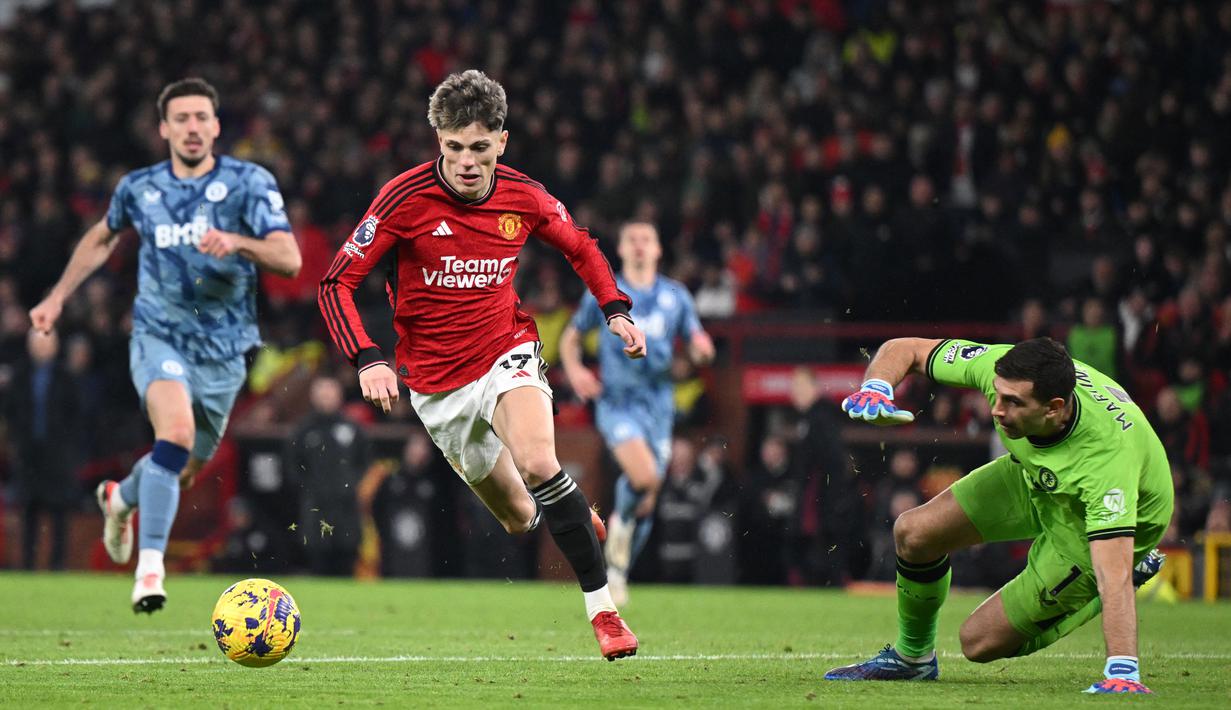 Alejandro Garnacho (dua kiri), berhasil mengelabui kiper Aston Villa, Emiliano Martinez yang membuahkan gol pertama bagi MU pada menit ke-59 dalam pertandingan pekan ke-19 Liga Inggris 2023/2024 yang berlangsung di Old Trafford, Rabu (27/12/2023). (AFP/Oli Scarff)