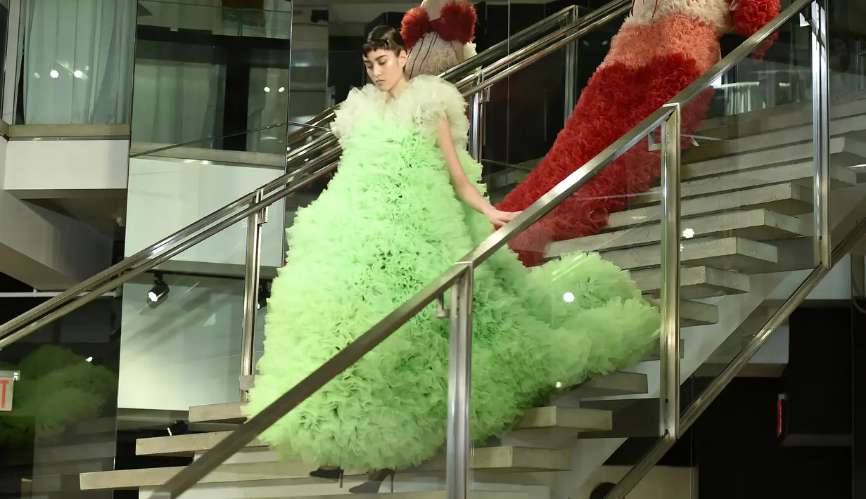 Seorang model berjalan di runway mengenakan koleksi busana rancangan desainer Jepang, Tomo Koizumi  pada New York Fashion Week di Marc Jacobs Madison, 8 Februari 2019. Koizumi menampilkan parade gaun awan berwarna pelangi (Steven Ferdman/Getty Images/AFP)