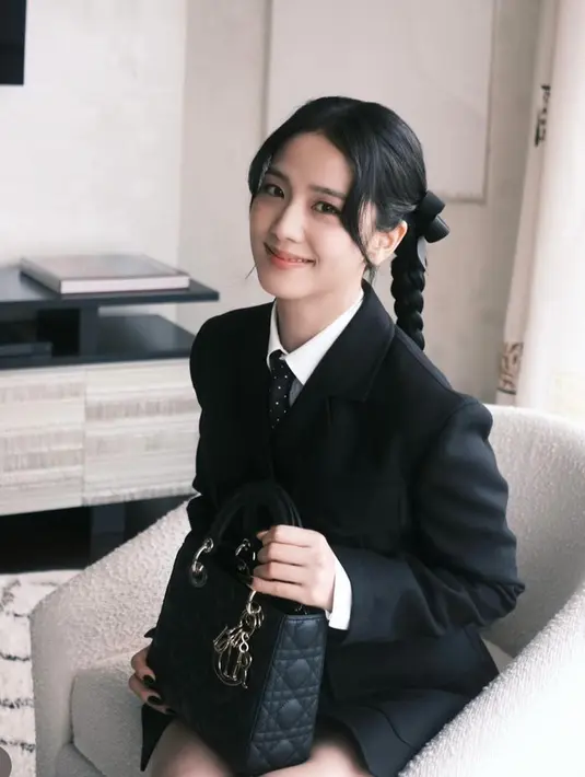 Jisoo melengkapinya dengan tas Dior hitam model My ABCDior seharga Rp93,9 jutaan. Rambut Jisoo ditata dalam dua kepang, dengan pita hitam di masing-masing kepang. Membuatnya tampilannya semakin seperti anak sekolah. [@sooyaaa__]