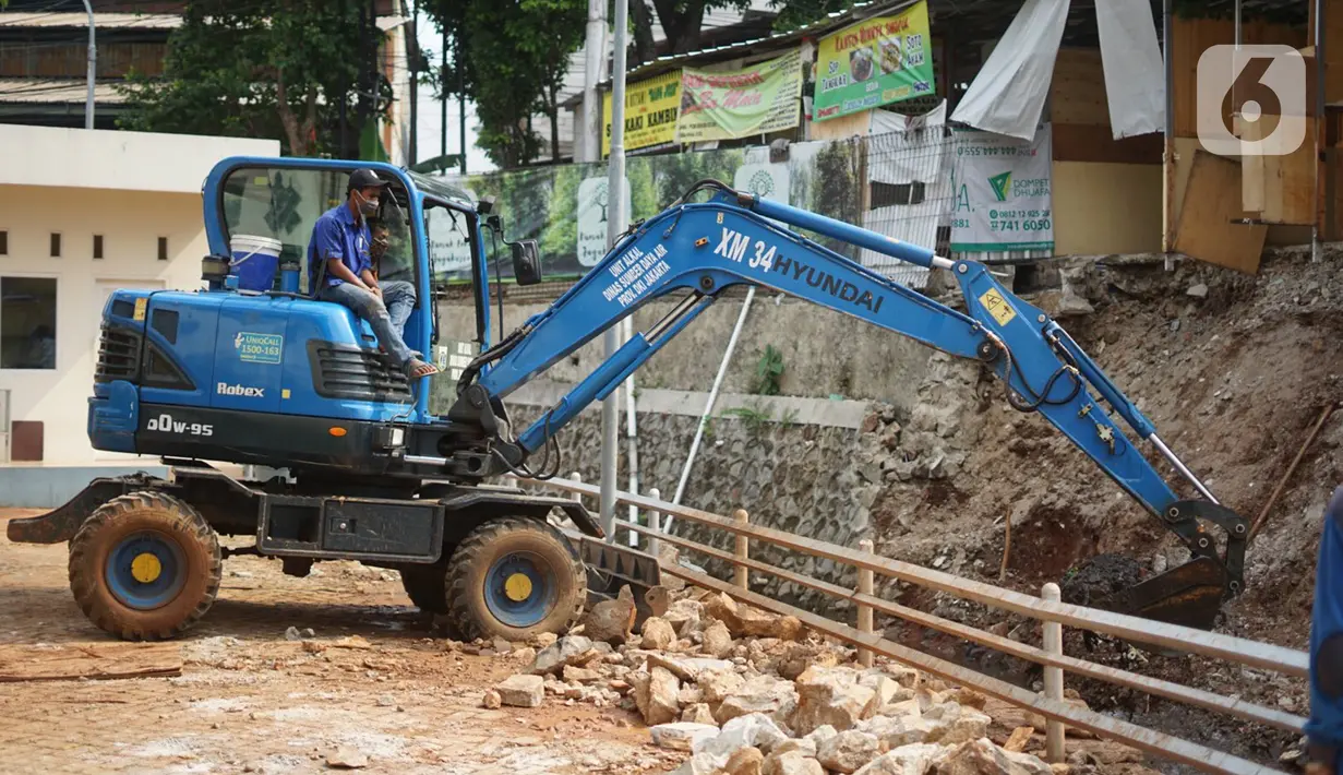 Alat berat mengeruk beton turap saluran air yang longsor di kawasan Jagakarsa, Jakarta, Kamis (17/9/2020). Selain karena hujan lebat, longsor diduga karena erosi tanah akibat pembuangan saluran air pencuci piring dan toilet dari warung makan di sekitar bantaran. (Liputan6.com/Immanuel Antonius)