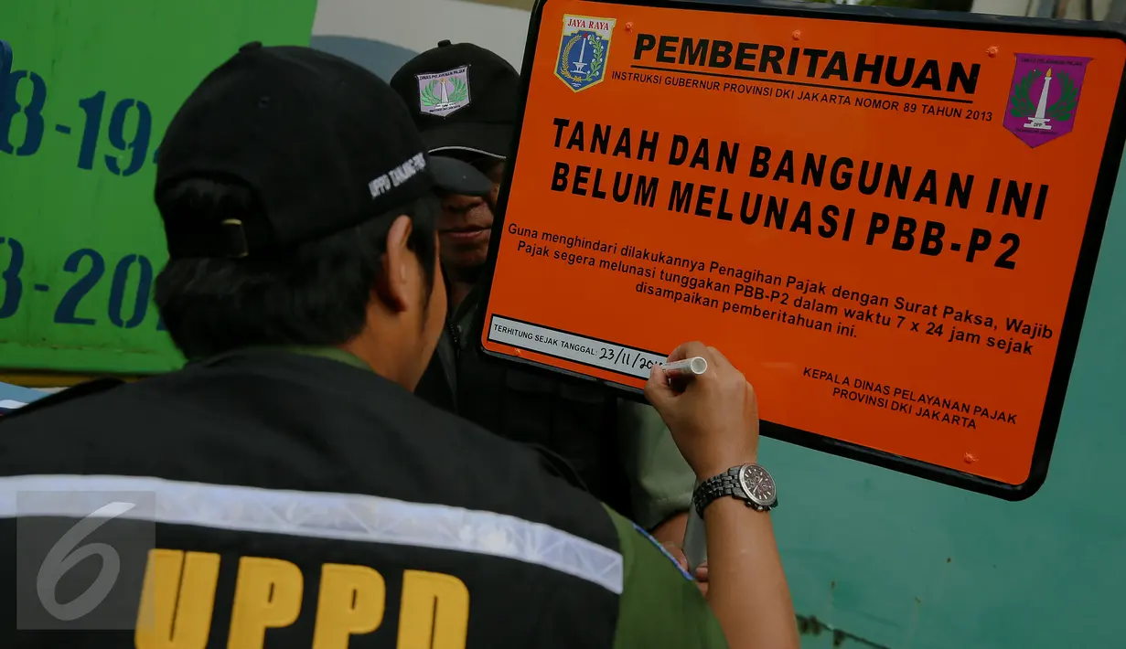 Petugas menulis keterangan pada plang di depan PT DKB Dok Perkapalan Galangan I, Tanjung Priok, Jakarta, Senin (23/11). Langkah ini sebagai peringatan bagi para wajib pajak (WP) kelas menengah ke atas mencapai ratusan miliar (Liputan6.com/Faizal Fanani)