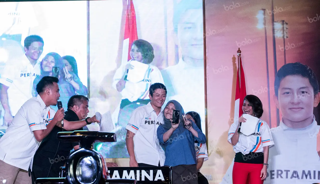 Seorang pengunjung Mall Kota Kasablanka yang beruntung diberi kesempatan untuk selfie bersama pebalap F1 pertama dari Indonesia, Rio Haryanto. (Bola.com/Vitalis Yogi Trisna)