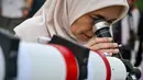 Rukyat dapat dilakukan dengan mata telanjang atau menggunakan alat bantu optik seperti teleskop dan kamera digital modern untuk meningkatkan akurasi. Rukyat berbeda dengan hisab. Tampak dalam foto, seorang wanita mengamati bulan, menjelang Idul Fitri sekaligus menandai berakhirnya bulan suci Ramadan1447 Hijriah melalui teleskop di kantor observatorium, pantai Lhoknga, Aceh pada Kamis 19 Maret 2026. (CHAIDEER MAHYUDDIN/AFP)