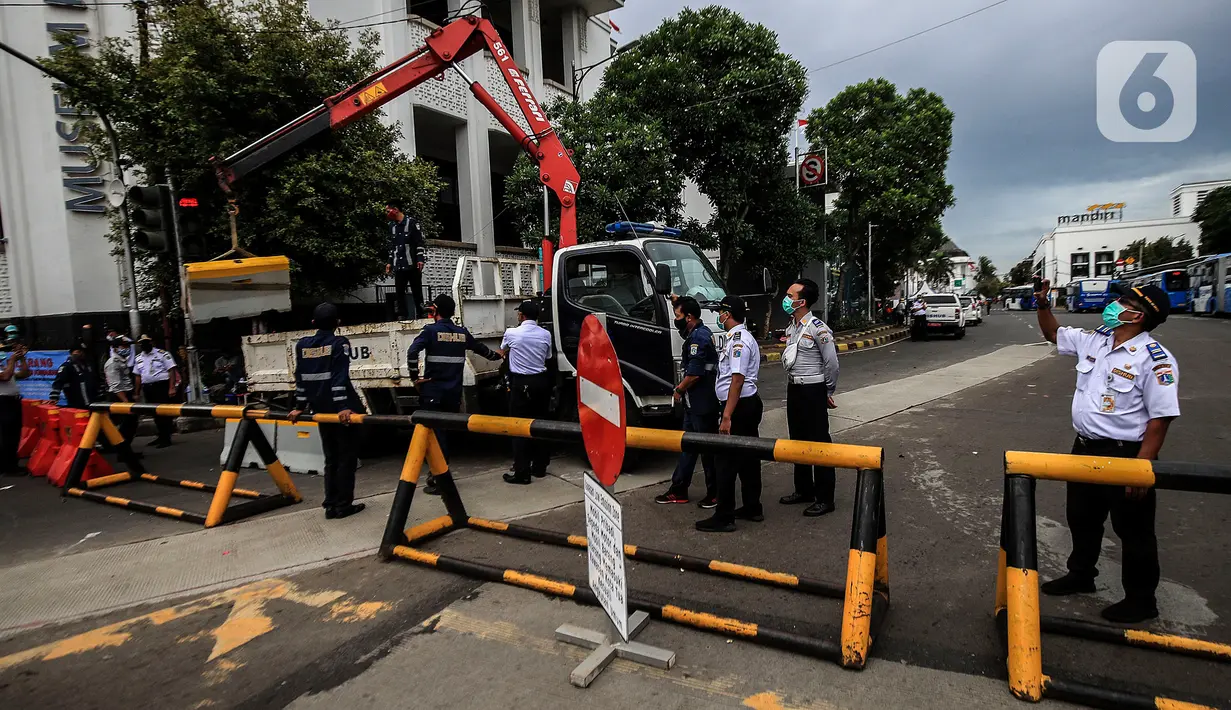 Suasana penutupan akses jalan menuju kawasan Kota Tua, Jakarta Barat, Jumat (18/12/2020). Pemerintah DKI Jakarta melarang kendaraan pribadi memasuki kawasan Kota Tua Jakarta mulai 18 hingga 23 Desember 2020 seiring penerapan kawasan rendah emisi atau Low Emission Zone. (Liputan6.com/Johan Tallo)