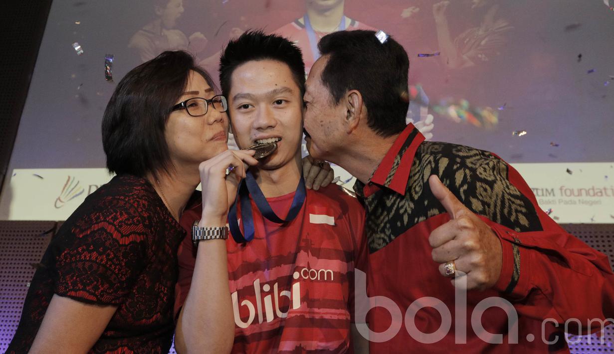 Juara All England 2017, Kevin Sanjaya, dicium kedua orang tuanya. Kemenangan ini pun mengantarkannya menjadi ganda putra nomor satu dunia dari sebelumnya di peringkat empat BWF. (Bola.com/M Iqbal Ichsan)