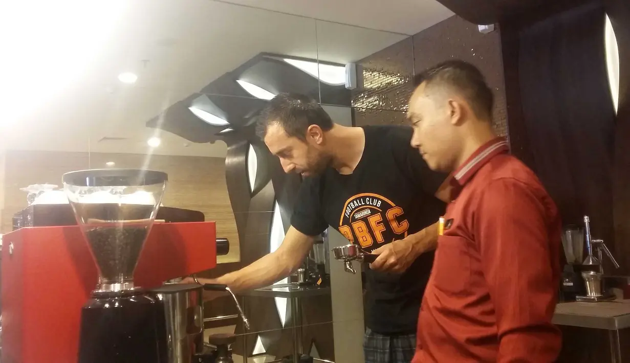 Pemain Pusamania Borneo FC, Goran Gancaev (kiri) belajar menjadi barista sebelum bertanding pada lanjutan Piala Jenderal Sudirman di Surabaya,Sabtu (21/11/2015). (Bola.com/Vitalis Yogi Trisna)