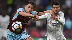 Bek Burnley, James Tarkowski berebut bola dengan striker Chelsea, Alvaro Morata pada laga tunda pekan ke-31 Premier League di Turf Moor, Jumat (20/4). Gol bunuh diri Kevin Long dan tembakan Victor Moses memenangkan Chelsea dengan skor 2-1 (OLI SCARFF/AFP)