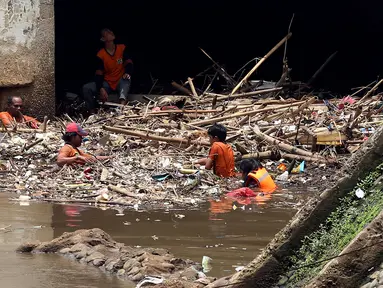 Pasukan Orange mengangkat sampah yang terbawa arus sungai di Pintu air Manggarai, Jakarta, Senin (2/10). Pembersihan itu dilakukan untuk melancarkan aliran Sungai Ciliwung yang melewati Pintu Air Manggarai (Liputan6.com/Johan Tallo)