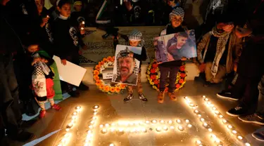 Warga Palestina menyalakan lilin dalam acara renungan menjelang peringatan 11 tahun wafatnya mantan Presiden Yasser Arafat, di Ramallah, Tepi Barat, Selasa (10/11) malam waktu setempat. (AFP PHOTO / ABBAS Momani)