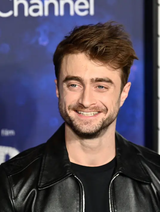 Daniel Radcliffe berpose sambil tersenyum saat menghadiri pemutaran perdana film "Weird: The Al Yankovic Story" di Alamo Drafthouse Cinema Downtown Brooklyn di New York pada Selasa, 1 November 2022. Daniel Radcliffe tampil keren dalam balutan jaket kulit dan t-shirt hitam di acara tersebut. (AFP/ANGELA WEISS)