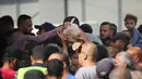 Warga Palestina menerima sekantong roti dari toko roti amal di kamp pengungsi Nuseirat, yang terletak di Jalur Gaza tengah, pada 2 November 2025. Melalui mekanisme pengiriman 2720 yang disahkan oleh Dewan Keamanan PBB, bantuan terus disalurkan ke Gaza. (EYAD BABA/AFP)