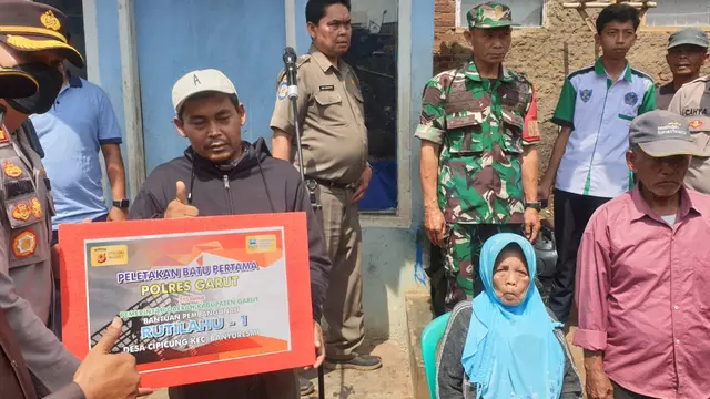 Kapolres Garut AKBP Wirdhanto Hadicaksono menyerahkan simbolis pembangunan rumah Undang (Bertopi), korban jerat rentenir di Kecamatan Banyuresmi, Garut. (Liputan6.com/Jayadi Supriadin)