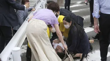 Mantan Perdana Menteri Jepang Shinzo Abe (tengah) jatuh ke tanah di Nara, Jepang barat, Jumat (8/7/2022). Abe pingsan setelah ditembak di Nara. Beberapa media melaporkan bahwa Shinzo Abe ditembak dari belakang, kemungkinan dengan senapan. (Kyodo News via AP)