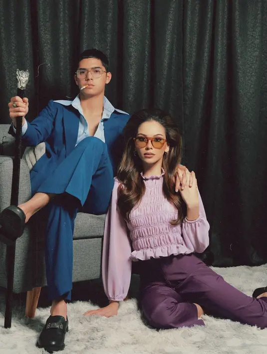 Posisi duduk mereka, dengan Al yang santai di kursi dan Alyssa yang berpose di lantai dengan tangan di pundak Al, menghadirkan suasana harmonis namun penuh pesona. Mereka menggunakan kacamata berwarna yang semakin memperkuat kesan vintage, memberi nuansa elegan ala era 70-an. Kombinasi ini berhasil menciptakan potret yang tak hanya meniru, tapi juga memberi nuansa baru dari gaya klasik Elvis dan Priscilla. (Liputan6.com/IG/@alyssadaguise)