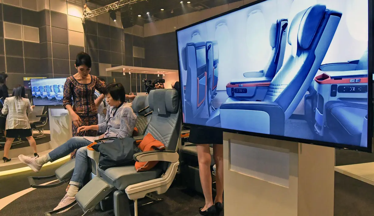 Pramugari menunjukkan kursi premium economy class kepada tamu saat peluncuran kabin terbaru di Singapura, Kamis (2/11). Berbagai fasilitas mewah dihadirkan di kabin pesawat tersebut. (AFP Photo/Roslan Rahman)
