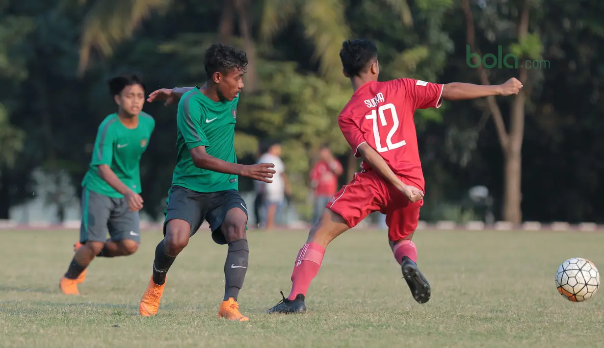 Pemain Timnas Indonesia U-16, Hamsa Lestaluhu (kiri) berebut bola dengan pemain Top Skor U-16  pada laga uji coba di Lapangan Atang Sutresna, Cijantung, Kamis (10/5/2018). Tim Top Skor U-16 menang 2-0 atas Timnas Indonesia U-16. (Bola.com/Nick Hanoatubun)