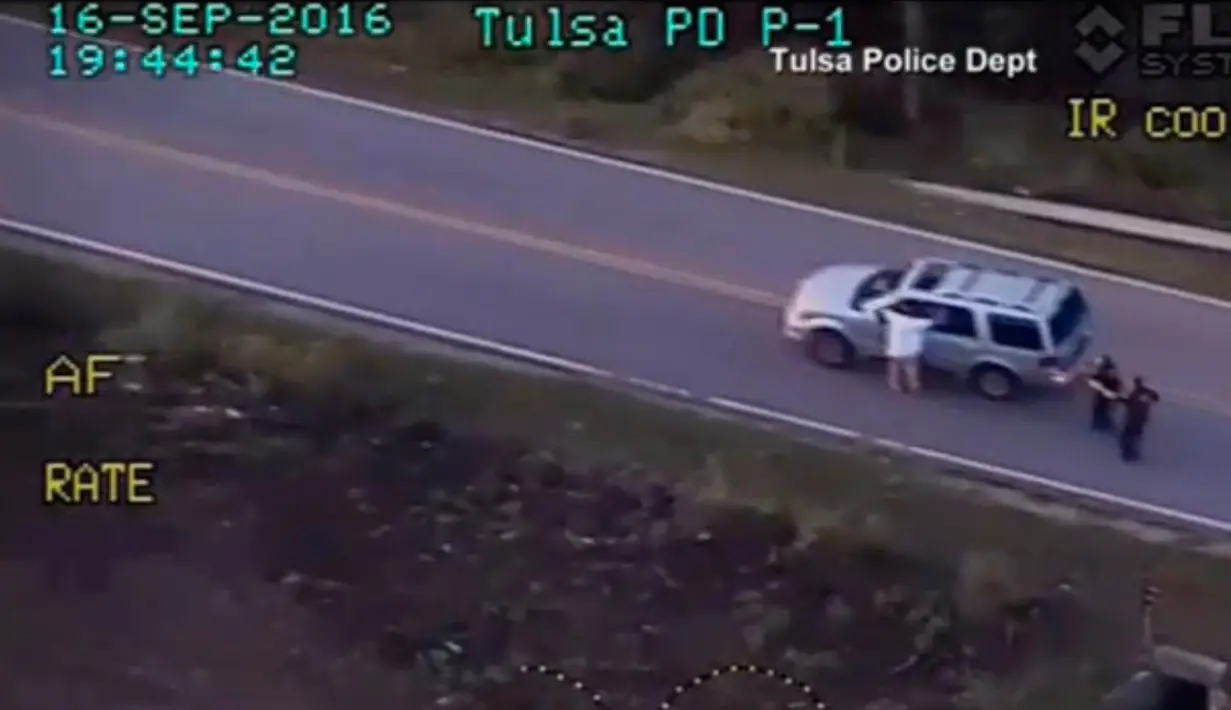 Seorang warga kulit hitam mengangkat tangan saat polisi mengarahkan senjata ke arahnya, Tulsa, Oklahoma, AS, (16/9). Diduga tak mau menyerahkan diri, polisi menembak korban hingga tewas. (REUTERS)