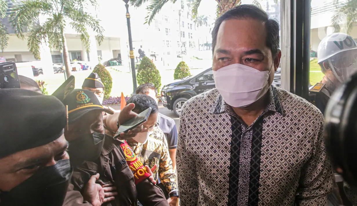 Mantan Menteri Perdagangan (Mendag) Muhammad Lutfi tiba memenuhi panggilan pemeriksaan di Gedung Bundar Kejaksaan Agung (Kejagung), Jakarta Selatan, Rabu (22/6/2022). Muhammad Lutfi yang mengenakan baju batik lengan panjang dan membawa tas berwarna hitam di tangannya terlihat didampingi oleh beberapa orang. (Liputan6.com/Faizal Fanani)