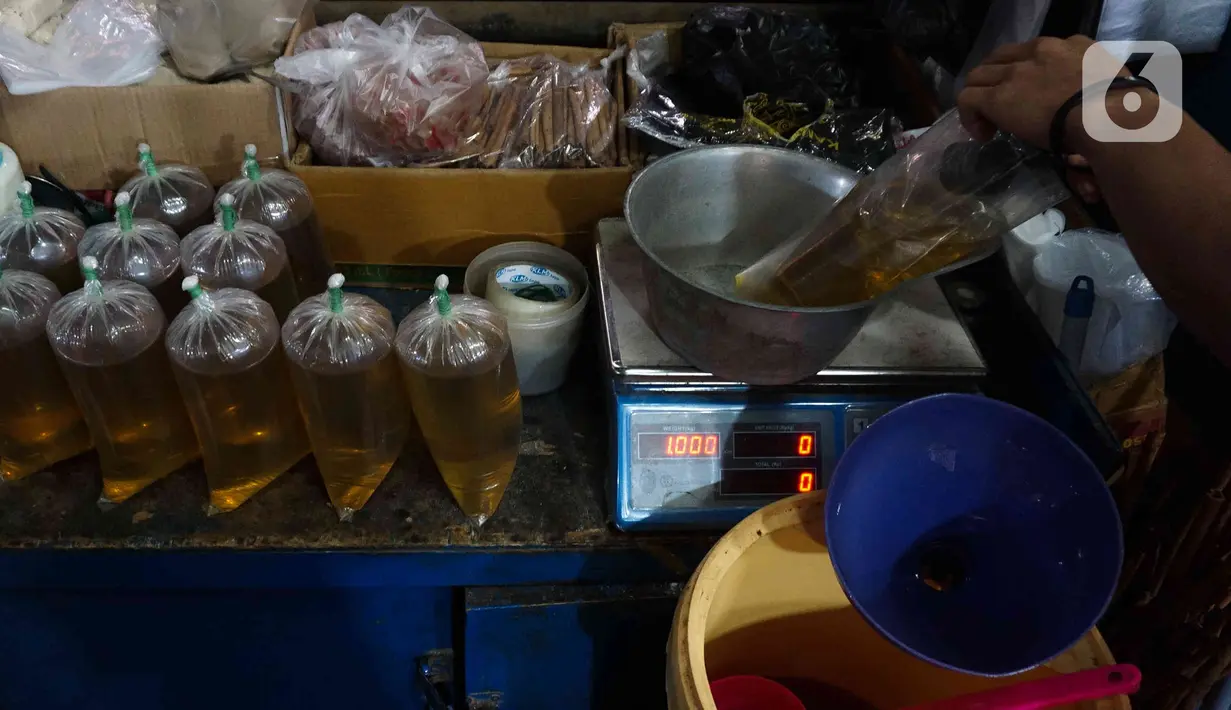 Pedagang menimbang minyak goreng curah di Pasar Senen, Jakarta, Selasa (31/5/2022). Pencabutan menyusul dikeluarkannya Permendag Nomor 30 Tahun 2022 yang mengatur ketentuan ekspor CPO dan turunan lainnya dan Permendag Nomor 33 Tahun 2022 tentang Tata Kelola Minyak Goreng Curah Sistem DMO-DPO. (Liputan6.com/Herman Zakharia)