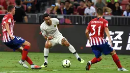 Penyerang Paris Saint-Germain (PSG), Angel Di Maria, berusaha melewati pemain Atletico Madrid pada laga ICC 2018 di Stadion Nasional Singapura, Senin (30/7/2018). PSG menang 3-2 atas Atletico Madrid. (AFP/Roslan Rahman)