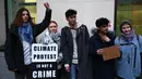 Aktivis lingkungan Swedia Greta Thunberg (kedua kiri) dan Christofer 'Chris' Kebbon (kiri) berpose sambil memegang plakat bertuliskan: "Protes iklim bukanlah kejahatan" di luar Pengadilan Westminster Magistrates di London pada tanggal 2 Februari 2024, (HENRY NICHOLLS/AFP)