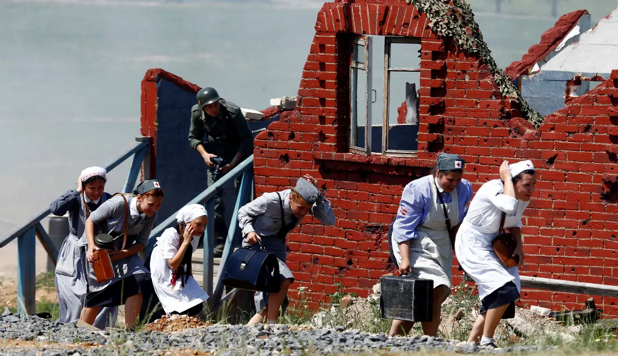 Adegan rekonstruksi yang menampilkan perjuangan tim medis ketika terjadi pertempuran saat memainkan rekonstruksi Perang Dunia II, di Memorial "Stalin Line", dekat Desa Goroshki, Belarusia, (2/7). (Reuters/Vasily Fedosenko)