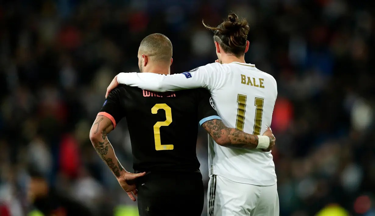 Pemain Manchester City Kyle Walker (kiri) dan pemain Real Madrid Gareth Bale berangkulan pada akhir laga leg pertama babak 16 Liga Champions di Stadion Santiago Bernabeu, Madrid, Spanyol, Rabu (26/2/2020). Manchester City menang 2-1. (AP Photo/Manu Fernandez)