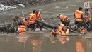 Pasukan oranye membersihkan sampah yang tersangkut di aliran sungai Ciliwung di kawasan Sudirman, Jakarta, Jumat (9/2). Meningkatnya debit air di Bendungan Katulampa, aliran air yang masuk ke Sungai Ciliwung membawa sampah. (Liputan6.com/Faizal Fanani)